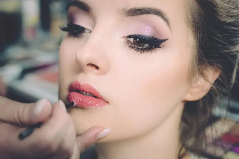 Close-up of a woman with softly winged eyeliner and pink lips