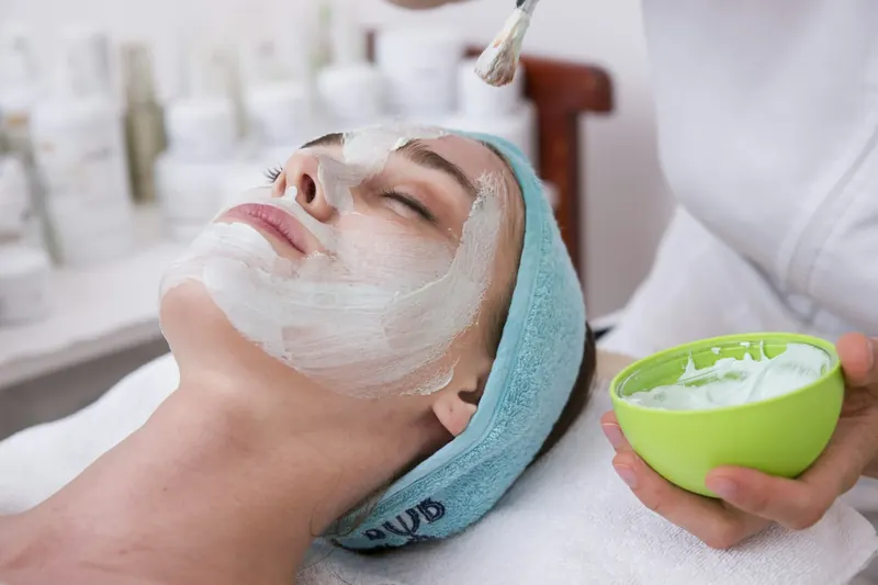 A woman relaxing with a cream mask during a facial treatment